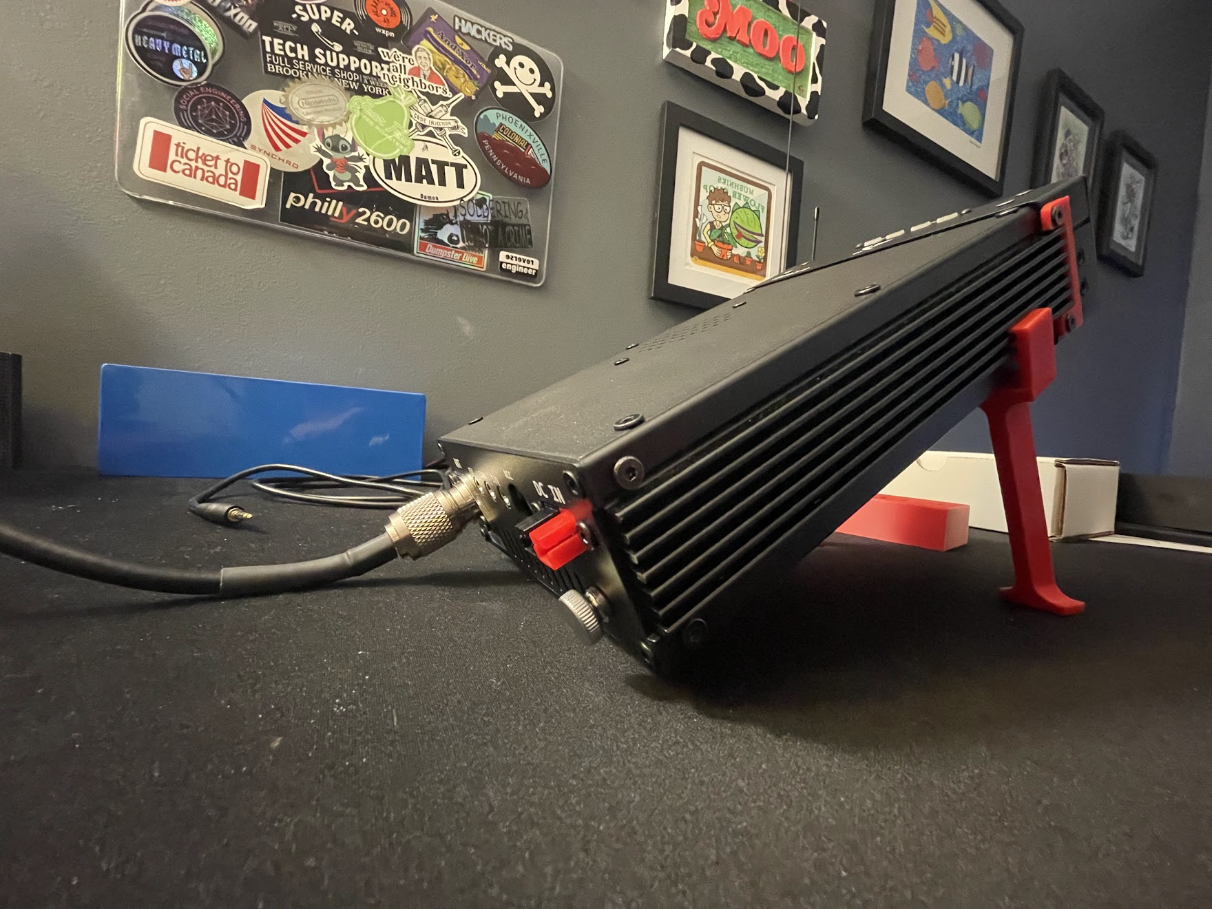 A rear angle of the radio mounted in the new stand with a coax cable attached. The coax cable is pressed against the table.